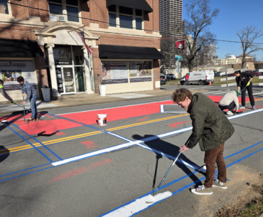 Matt McCoy paints the street in front of Taborian Hall