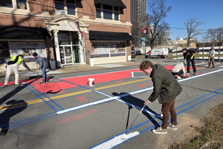 Matt McCoy paints the street in front of Taborian Hall