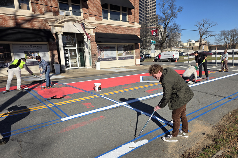 Matt McCoy paints the street in front of Taborian Hall